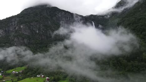 Drohnenvideo-Eines-In-Wolken-Gehüllten-Wasserfalls-Am-Ende-Eines-Norwegischen-Sees