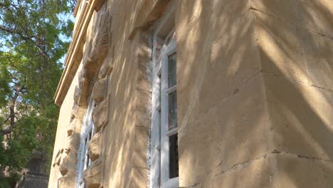 Gealtertes-Fenster-An-Den-Gelben-Wänden-Von-Goolbai,-Karachi