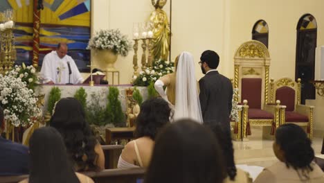 Young-Latin-couple-at-their-wedding-ceremony-in-Catholic-church