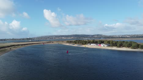 Aerial-Flyover:-People-Kite-Surfing-On-Fiesta-Island-Park-In-Mission-Bay,-San-Diego