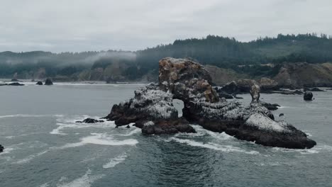 Waves-crashing-on-craggy-rock-formation-at-Indian-Beach-Oregon-on-a-foggy-day