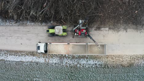 Aerial-static-top-down-view-of-wood-chipper-shred-wood-from-pile-of-branches