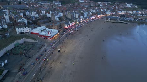 Aerial-drone-bird's-eye-view-over-beachside-town-houses-in-Scarborough,-North-Yorkshire,-England-during-evening-time