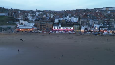 Aerial-drone-pan-shot-from-right-to-left-over-beachside-town-houses-in-Scarborough-in-North-Yorkshire,-England-UK-at-dusk