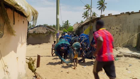 Gruppe-Afrikanischer-Menschen,-Die-Fischnetze-In-Einem-Dorf-In-Ghana-Transportieren