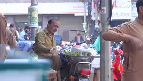 Filmische-Parallaxenaufnahme-Eines-Mannes-Mit-Seinem-Straßenstand-In-Der-Saddar-Bazar-Street-Tagsüber-In-Karachi,-Pakistan