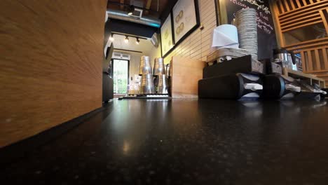 Low-angle-shot-inside-a-cafe-with-a-person-reaching-for-a-takeaway-cup-at-Starbucks