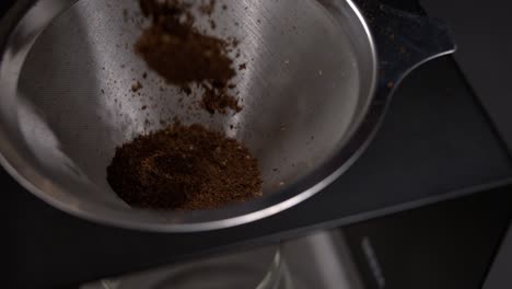 Ground-coffee-falling-into-a-pour-over-coffee-maker-in-super-slow-motion