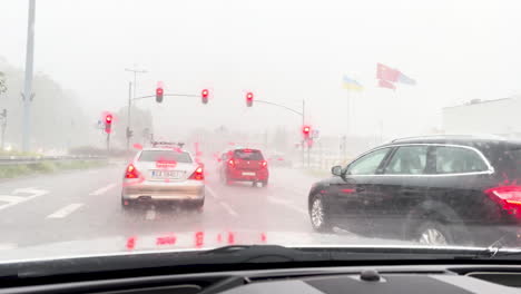 Blick-Aus-Der-Perspektive-Eines-Autofahrers-Während-Eines-Regenschauers,-Mit-Aktiven-Scheibenwischern-Und-Bremslichtern-Anderer-Fahrzeuge,-Die-Durch-Den-Regenguss-Leuchten