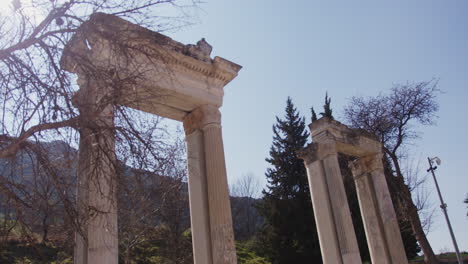 Looking-up-at-ancient-pillars-through-a-tree-in-Ephesus-with-a-lens-flare