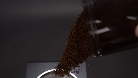 Pour-out-coffee-grinder-mug-into-a-coffee-machine-in-super-slow-motion
