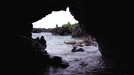 An-view-of-the-Cave-at-Black-Sand-Beach-in-Waianapanapa-State-Park-along-the-Road-to-Hana-in-East-Maui,-Hawaii,-a-popular-tourist-destination-along-the-Road-to-Hana