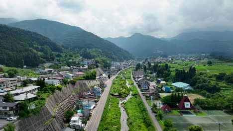 Aerial-ascending-shot-following-the-Yokoyu-river,-summer-day-in-Yamanochi,-Japan