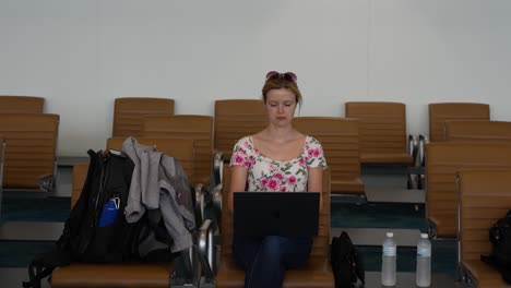 Junge-Kaukasische-Frau,-Die-Am-Flughafen-An-Einem-Computer-Arbeitet