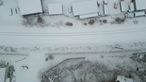 Aerial-top-down-tracking-follows-along-icy-snow-covered-railroad-tracks-in-winter