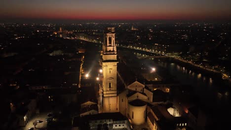 Rückwärts-Rotierende-Luftdrohnenaufnahme-Der-Kathedrale-Von-Verona-Bei-Nacht-Mit-Beleuchtetem-Glockenturm
