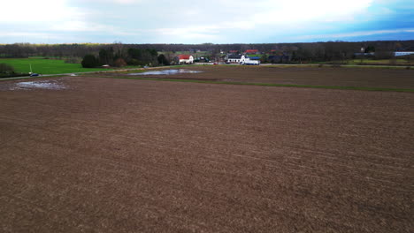 Drone-flies-low-over-empty-brown-muddy-sticky-field-in-Limburg