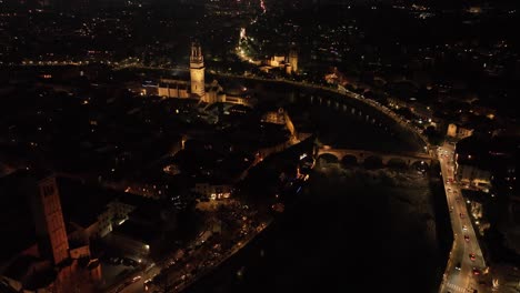 Aerial-Forward-lateral-Drone-Shot-of-Ponte-Pietra-Bridge-and-Verona-Cathedral-at-Night