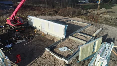 Aerial-shot-of-a-crane-positioning-a-house-panel-in-a-construction-site