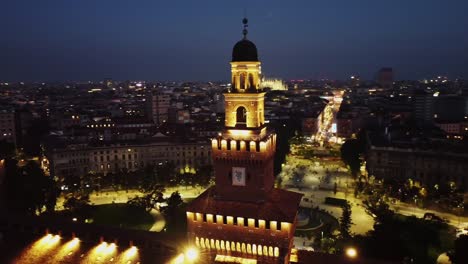 Magical-castle-of-Milan-at-night-with-glowing-lights,-aerial-orbit-view