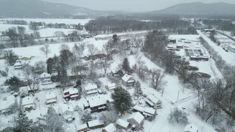Panoramic-aerial-flies-over-quaint-suburb-outside-of-downtown-Northampton-covered-in-snow