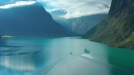 A-cruise-motorboat-crosses-a-wide-lake-with-turquoise-waters-of-Loenvatnet