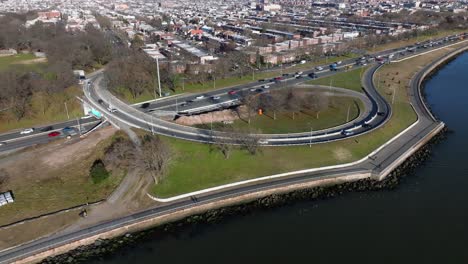 An-aerial-view-of-the-Belt-Parkway-in-Brooklyn,-NY-from-over-Gravesend-Bay-on-a-sunny-day