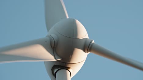 Dynamic-low-angle-view-of-a-wind-turbine-against-a-clear-sky,-highlighting-renewable-energy-infrastructure