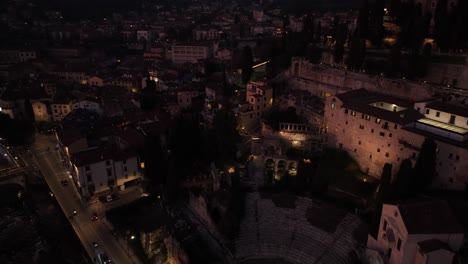 Aerial-lateral-panning-Reveal-Drone-Shot-of-Verona-Roman-Theater-at-Night-and-Bell-Tower-Cathedral
