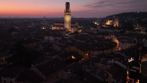 Aerial-Rotating-Reveal-Drone-Shot-of-Verona-Skyline-at-Night-with-Sunset,-till-Main's-Cathedral-Bell-Tower