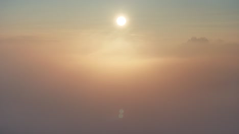 Sunrise-drone-view-panning-left-to-right-above-golden-winter-fog