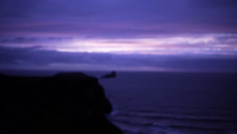 Mann-Mit-Blick-Auf-Klippen-Und-Das-Meer-Während-Eines-Faszinierenden-Violetten-Sonnenuntergangs