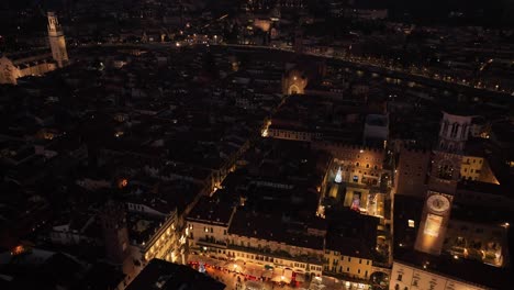 Aerial-Backward-Drone-View-of-Piazza-Erbe-and-Lamberti's-Tower-at-Night-Verona