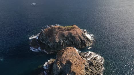 Drohnenvideo-über-Einer-Kleinen-Felsigen-Insel-Mit-Brechenden-Wellen