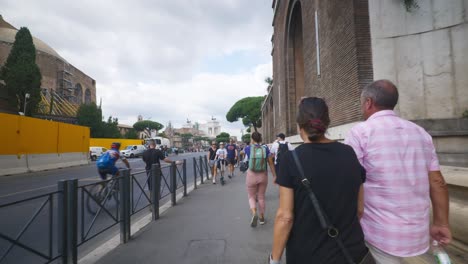 Rome-Immersive-POV:-Moving-In-Busy-Streets-to-Chiesa-Santi-Luca-e-Martina,-Italy,-Europe,-Walking,-Shaky,-4K-|-Girl-With-Backpack-Hurrying-By-Along-Busy-Sidewalk
