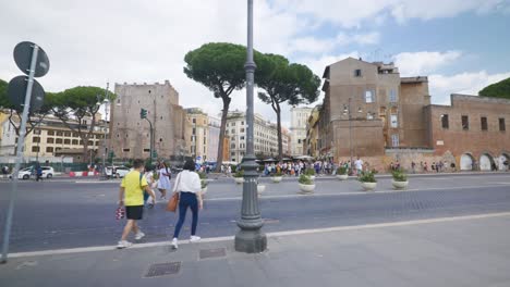 Punto-De-Vista-Inmersivo-En-Roma:-Moverse-Por-Calles-Concurridas-Hasta-Chiesa-Santi-Luca-E-Martina,-Italia,-Europa,-Caminar,-Tembloroso,-4k-|personas-Cruzando-La-Calle-Cerca-De-Las-Ruinas-Y-La-Ciudad