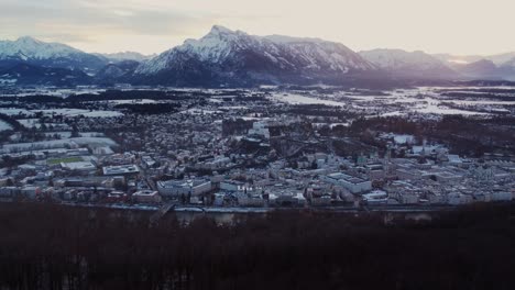4k-aerial-shot-of-Salzburg-cityscape-reveal-at-sunset,-Castle-and-Alps,-Austria