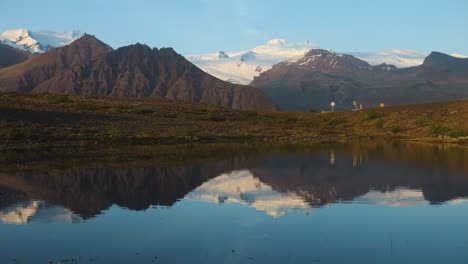 Iceland's-calm-mountain-landscape-with-clear-reflection-in-water,-warm-sunlight,-serene-dawn-ambiance