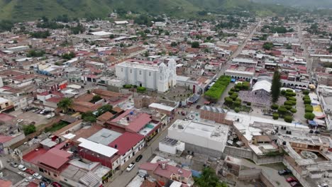 Aerial-tilt-up-shot-of-old-city-of-Tecalitlan-with-rustic-roofs-and-cathedral-during-daytime-in-Mexico