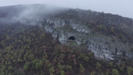 A-view-from-afar-through-a-drone-shot-of-Kozarnika-Cave,-located-in-the-Balkan-Mountain-range-in-Dimovo-Municipality,-Bulgaria