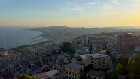 Ein-Weitreichender-Blick-Auf-Eine-Küstenstadt-Im-Morgen--Oder-Abendlicht,-Mit-Dicht-Gedrängten-Gebäuden-Auf-Einem-Hügel-Mit-Blick-Auf-Eine-Ruhige-Bucht-Von-Neapel,-Italien
