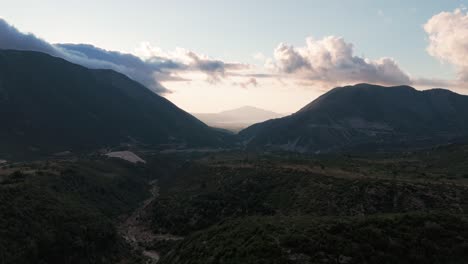 Aerial-descend-over-Albanian-mountain-gorge,-shady-hillside-during-sunset