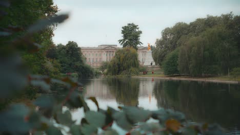 Buckingham-Palace-behind-the-lake-in-St-James-park,-London,-UK