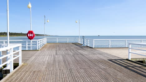 A-sunny-pier-with-white-railings-and-lamps