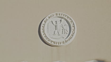 State-seal-of-New-Mexico-on-the-side-of-the-New-Mexico-State-capitol-building-in-Santa-Fe,-New-Mexico-with-stable-video-shot