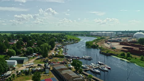 Luftpanorama-Fabrik-Fluss-Kanal-Dorf,-Schwimmende-Boote,-Grüner,-Sonniger-Tag