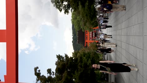 Menschenmassen-Gehen-Unter-Den-Torii-Toren-Fushimi-Inari-Buddhistischer-Schrein-Tempel-Hindurch,-Vertikale-Aufnahme