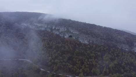 Approaching-drone-shot-and-panning-above-the-Kozarnika-Cave,-located-in-the-Balkan-Mountain-range,-in-Dimovo-Municipality,-in-Bulgaria