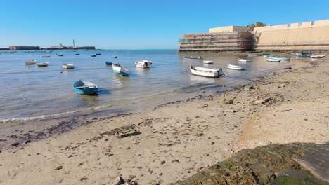 Small-boats-moored-near-the-ancient-sea-walls-of-Cádiz