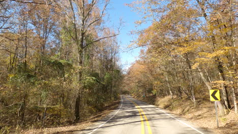 Fall-autumn-road-POV-driving-forward,-colorful-orange-foliage-trees,-USA